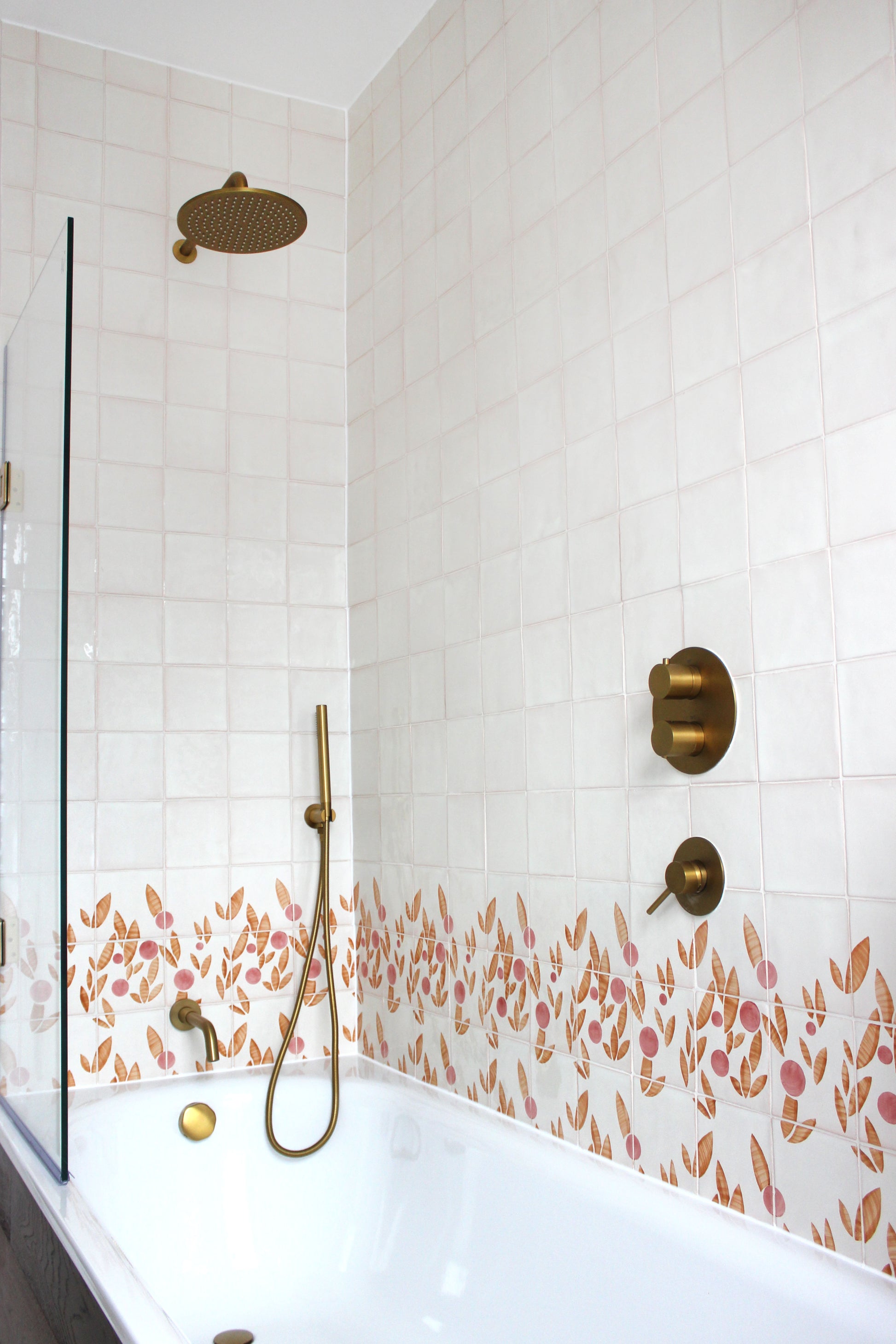 Cherry tile in Rust & Rose by Feild. Handmade and hand painted glazed terracotta tiles. Installed around a bath